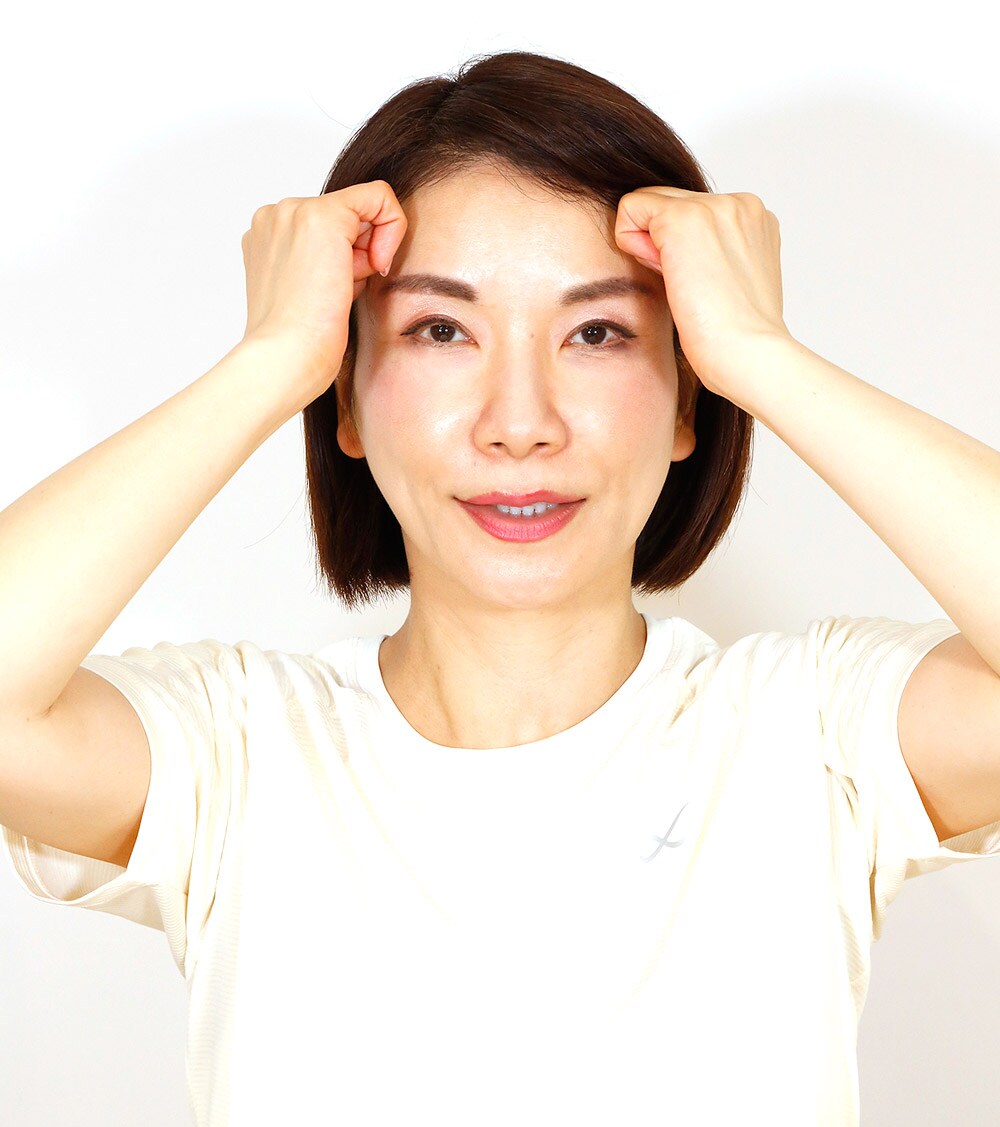 小さな円を描きながら刺激を与え、おでこからこめかみまで生え際(写真の点のライン)に沿って、まんべんなくほぐしていく。
