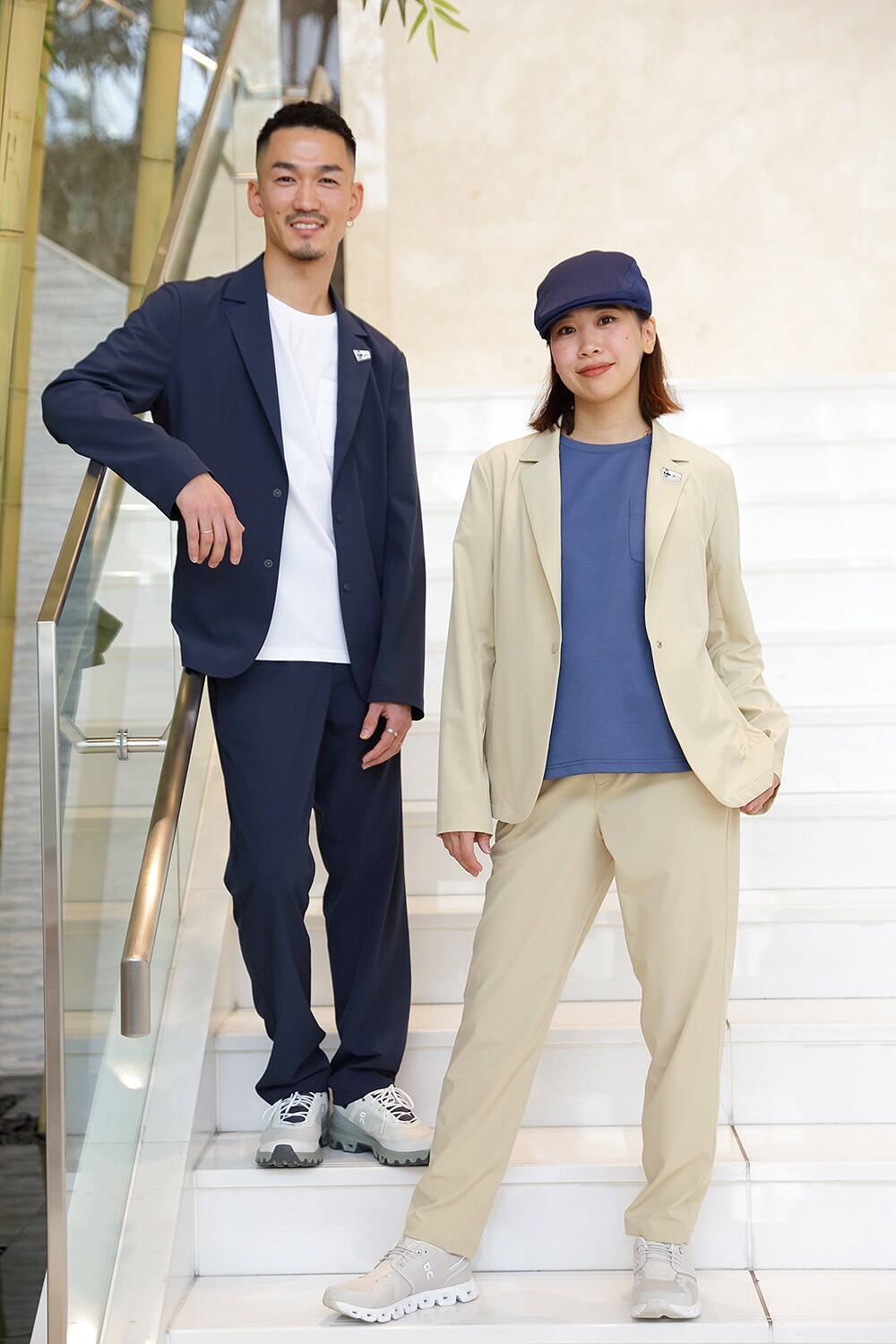 NEWTRADのメンバーからSTRさん(左)、AIさん(右)。スーツのサイズ展開はメンズ<S、M、L、LL>、レディス<M、L>、カラーはメンズ<スミクロ(上の写真で着用)、ネイビー>、レディス<ベージュ(上の写真で着用)、ネイビー)>