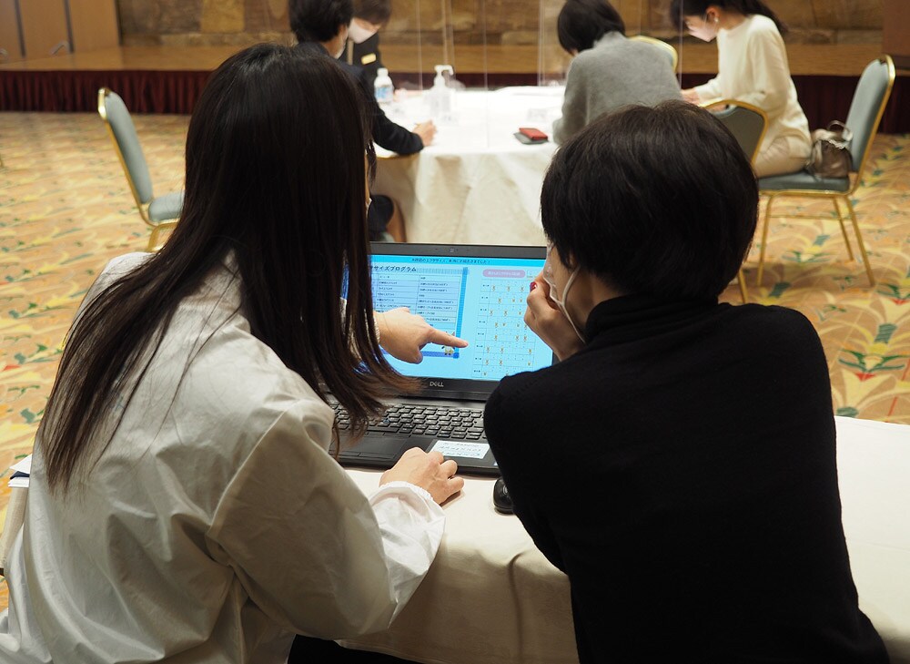 フィードバックでは、「週3回のエクササイズ、よくがんばりました」と研究員(左)からお褒めの言葉が。