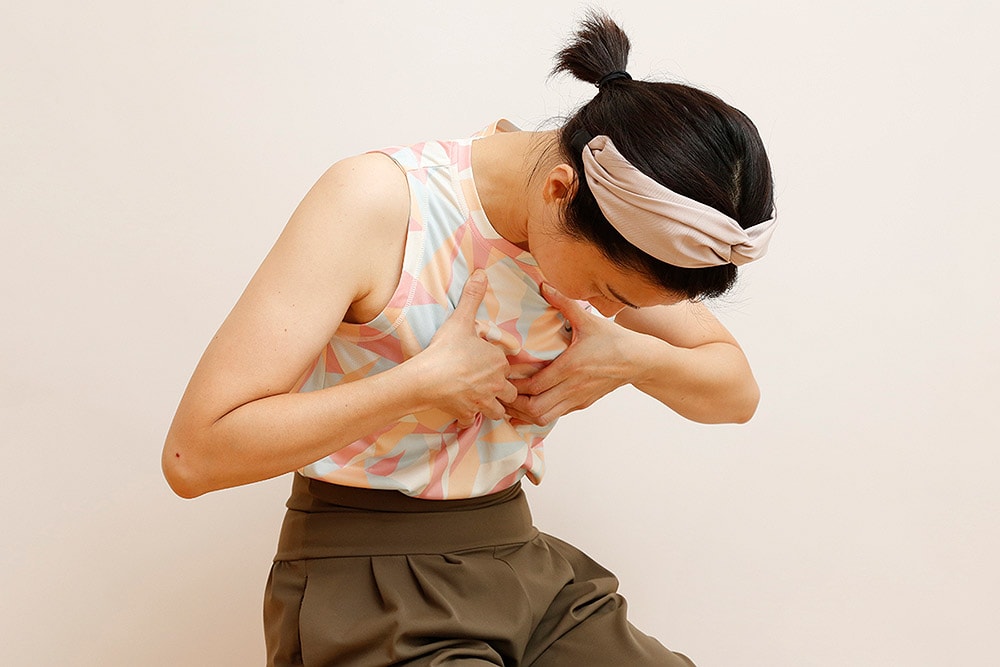筋肉をつまんだまま、下を向き背中を丸めて10回深く呼吸をする。